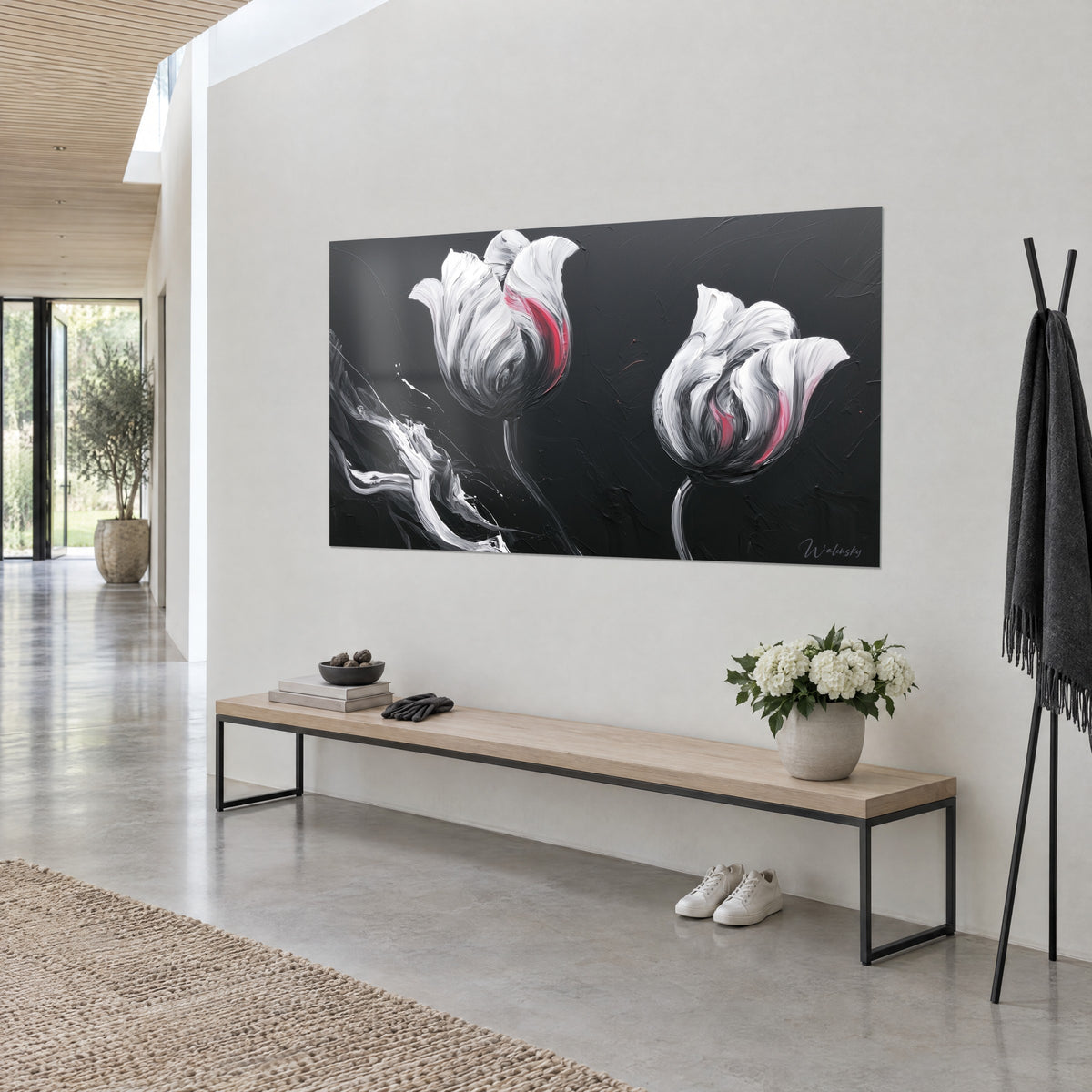 Tableau fleurs en empâtements d'acrylique ivoire et gris, deux corolles sur noir profond, banc bois et fleurs, vue de trois-quarts dans un hall