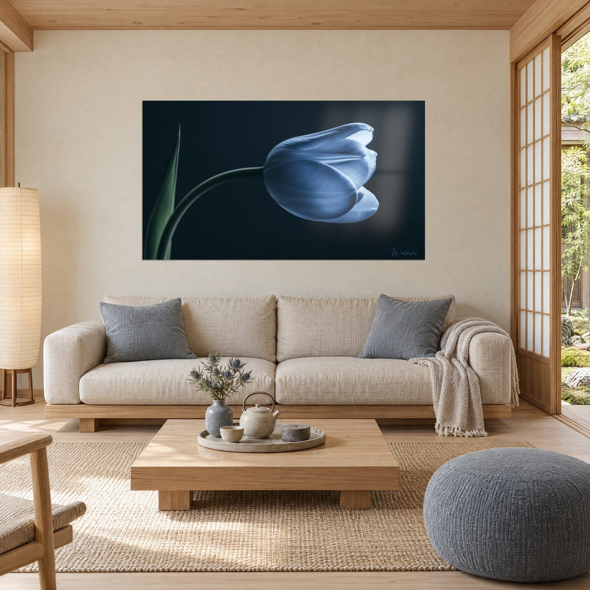 Tableau tulipe bleu pâle penchée sur sa tige verte, fond noir bleuté, au-dessus d'un canapé dans un salon lumineux
