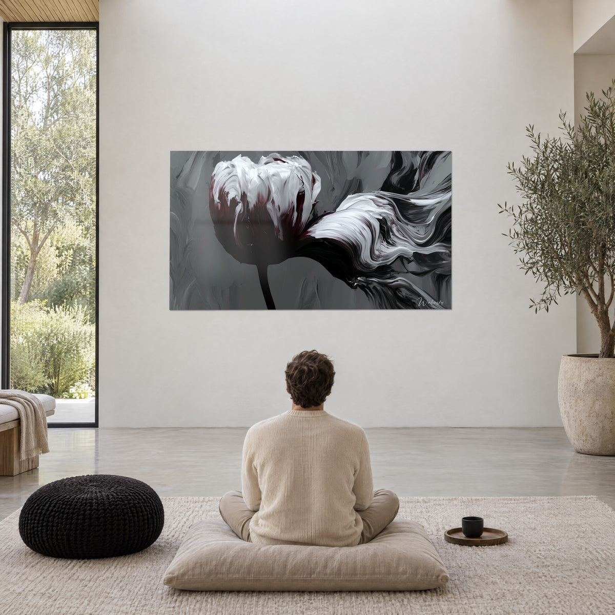 Tableau fleur éclatante aux traînées blanches soyeuses, rouge vin et noir, face à un homme de dos assis sur un coussin