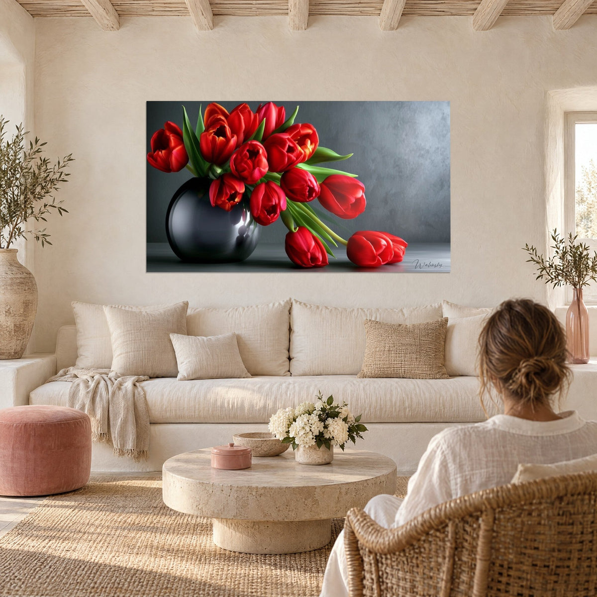 Tableau bouquet de tulipes écarlates débordant d'un vase anthracite brillant, fond gris texturé, au-dessus d'un canapé dans un salon lumineux