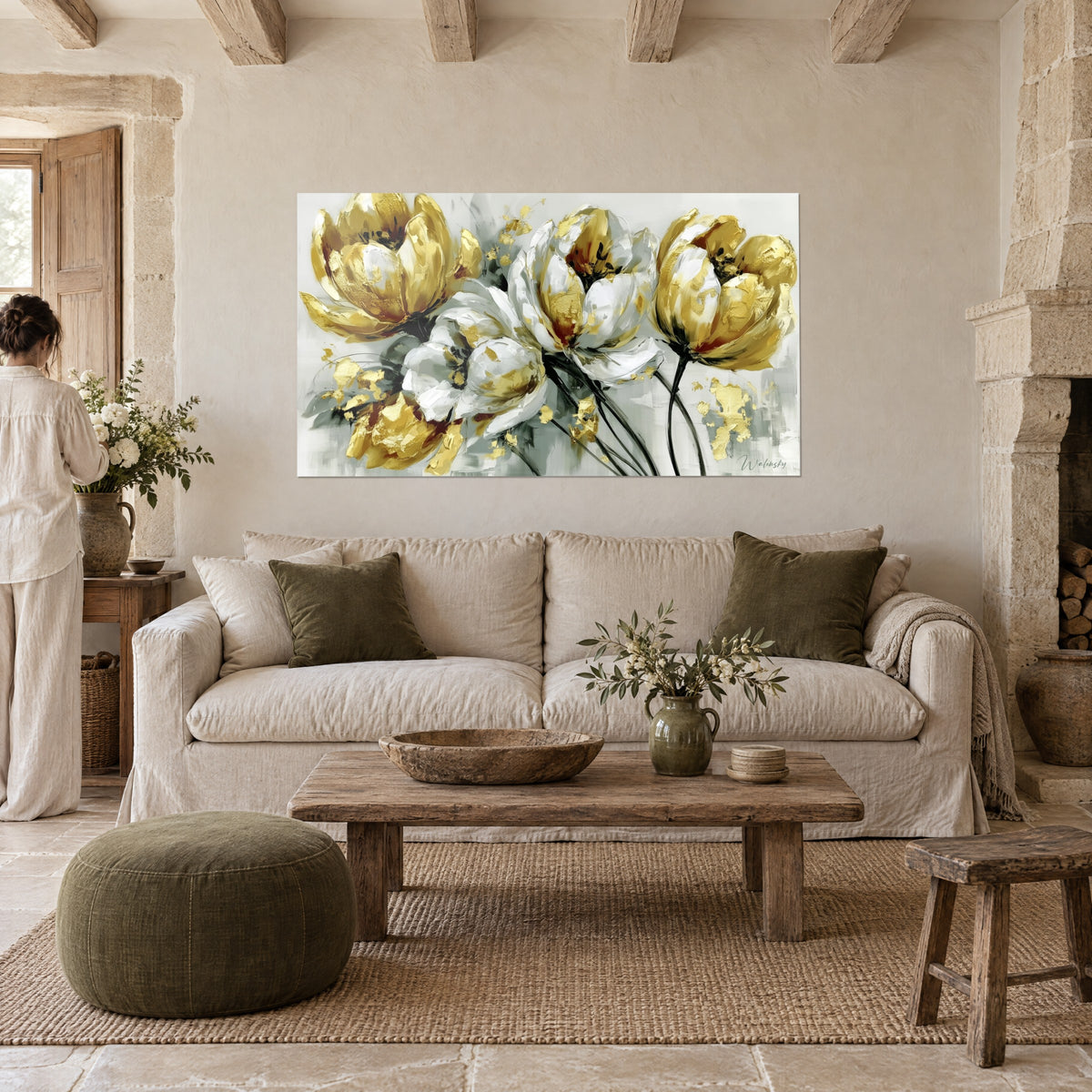 Tableau tulipes blanches aux pétales empâtés de feuilles d'or, regardé par une femme, au-dessus d'un canapé dans un salon lumineux
