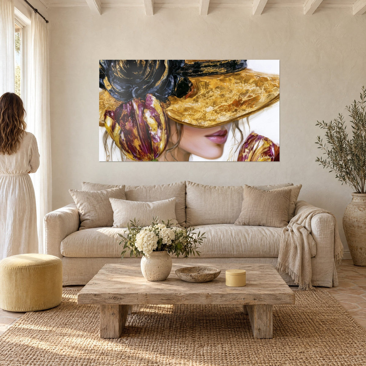 Wall art of a woman in a wide-brimmed gold hat and purple tulips, black rose in relief, above a sofa in a bright living room