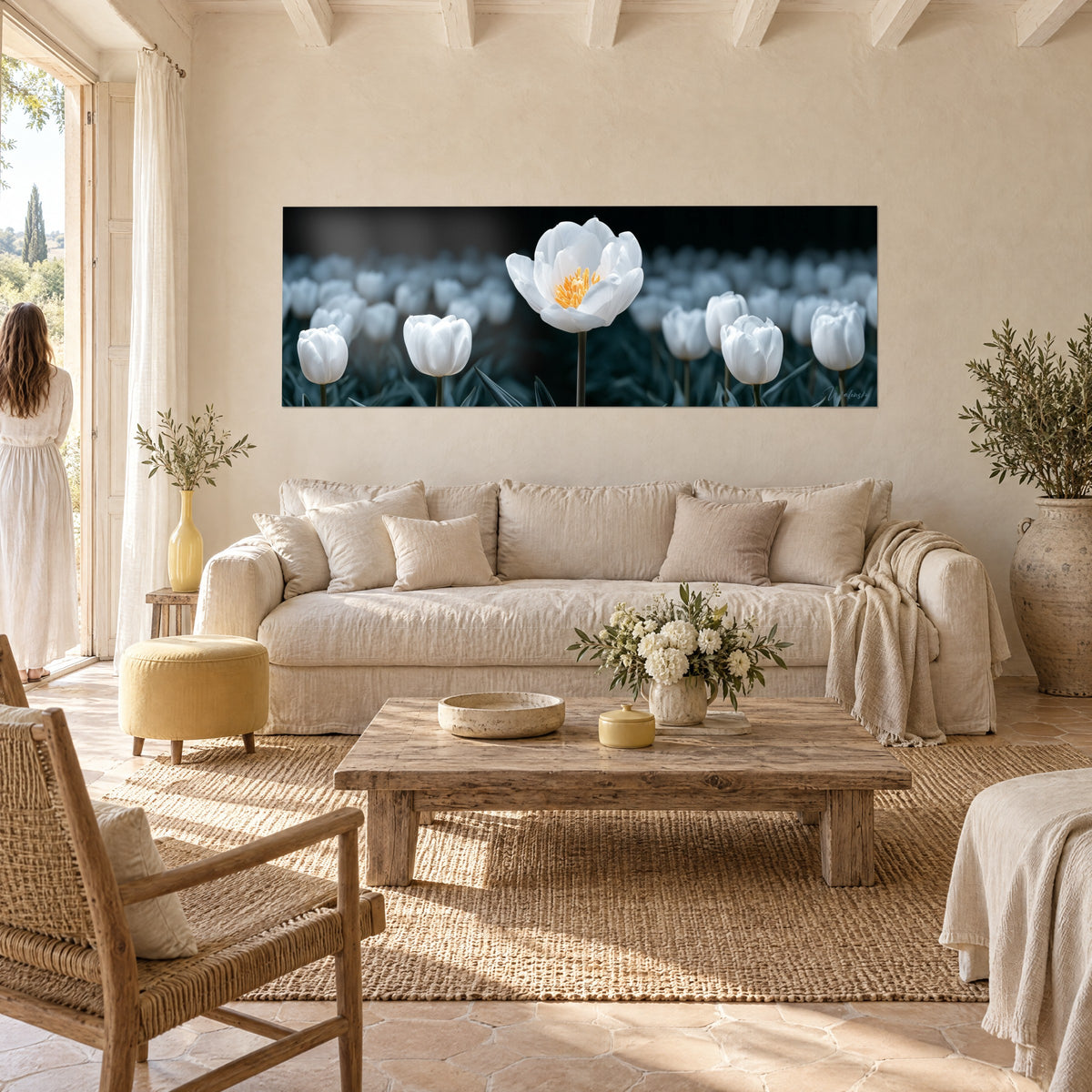 Tableau tulipe blanche épanouie au cœur orangé, fond bleu nuit, femme de dos, au-dessus d'un canapé dans un salon lumineux