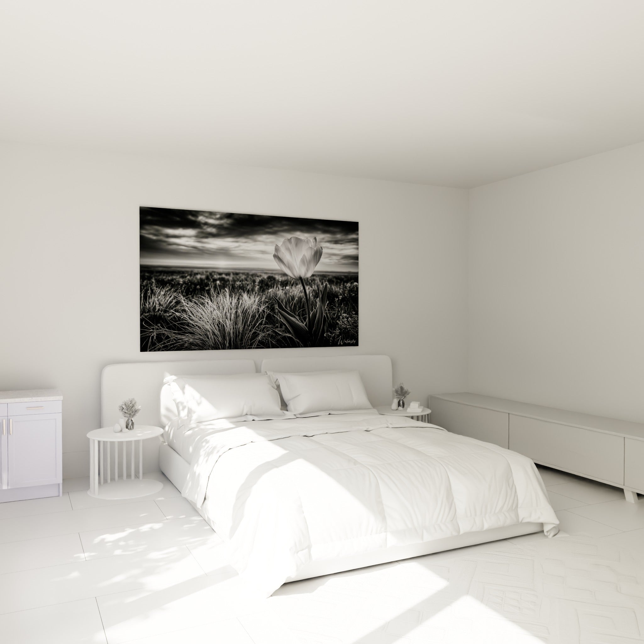 Fleur blanche solitaire aux herbes grises accrochée au-dessus d'un lit dans une chambre claire