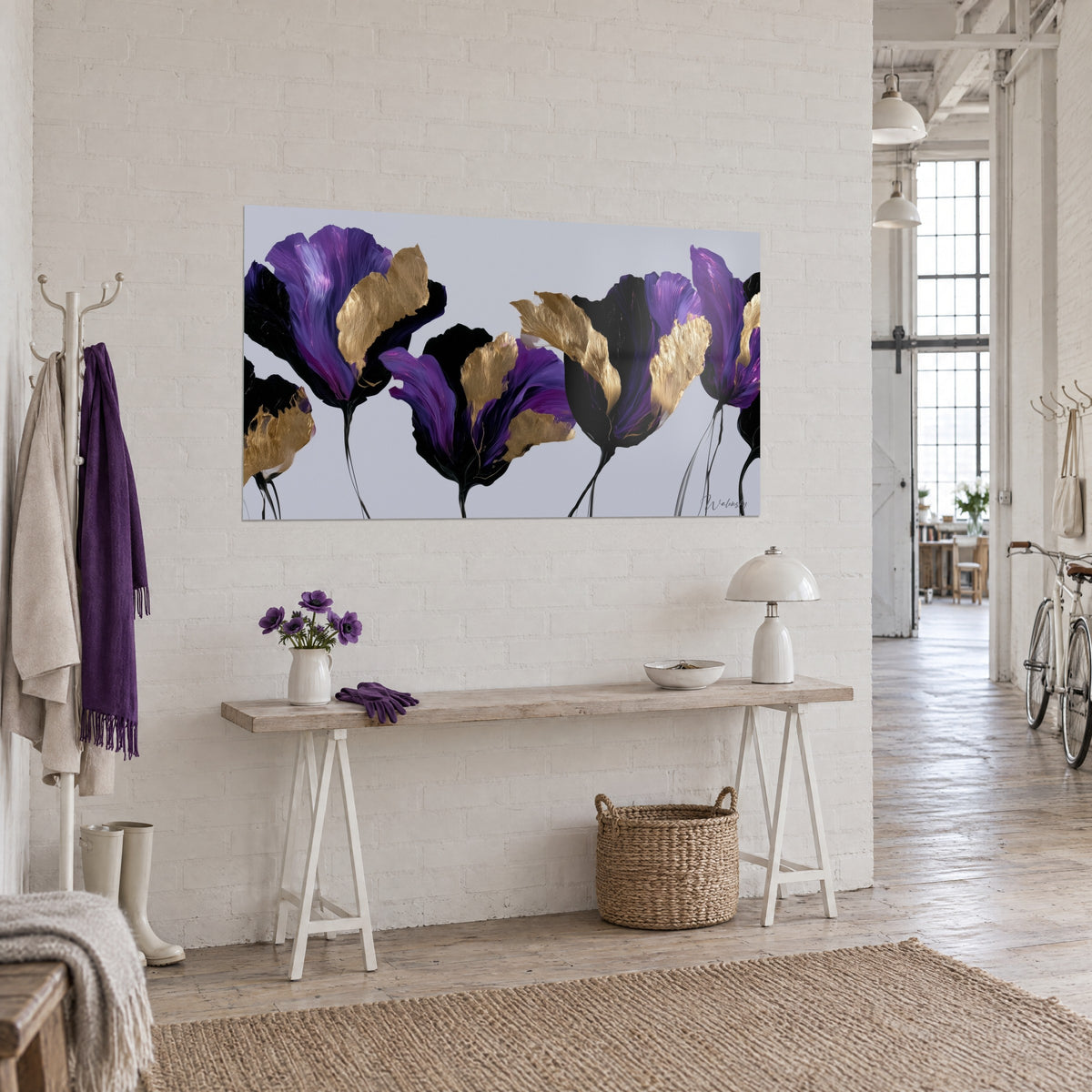 Wall art of a row of purple and gold flowers on grey background, fine black stems, hung above a light wood console in a loft