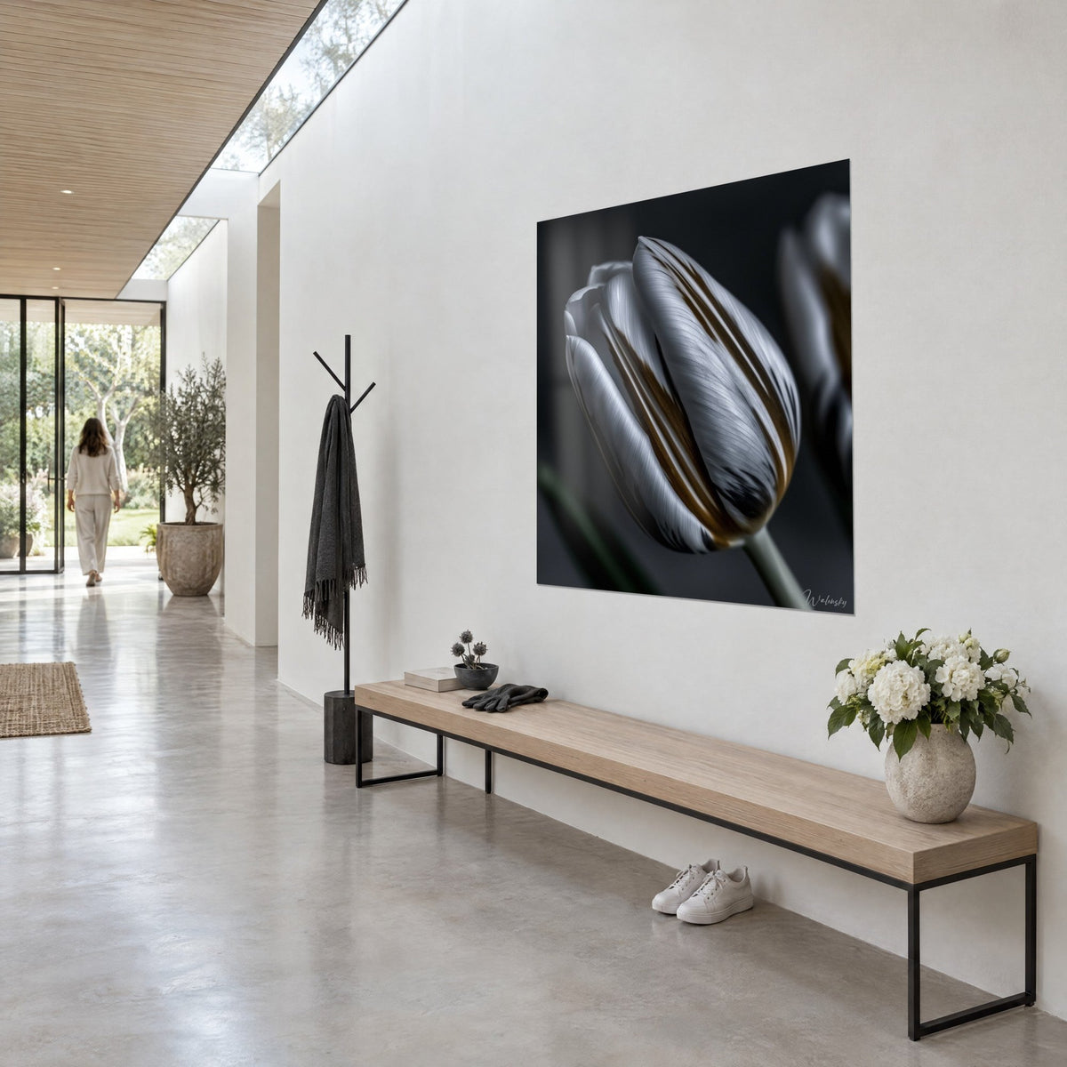 Quadro bocciolo di tulipano grigio perla venato di bronzo, petali satinati su fondo nero, in fondo al corridoio di una casa d'architetto