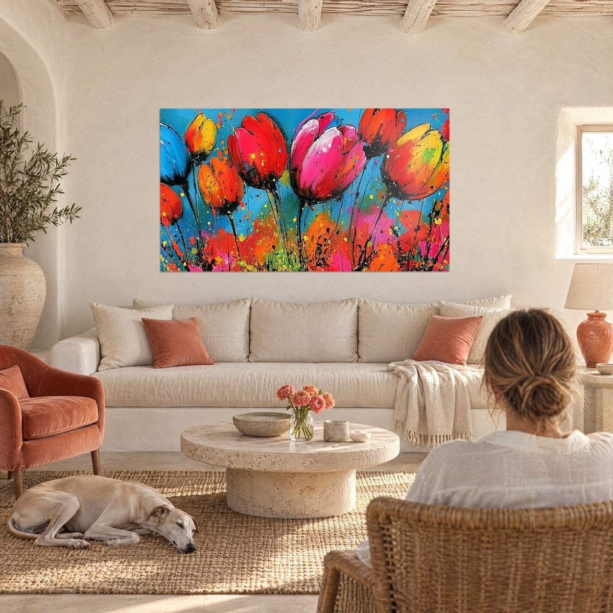 Cuadro tulipanes fucsia y rojos salpicados de pintura sobre fondo azul, tallos negros, encima de un sofá en un salón luminoso