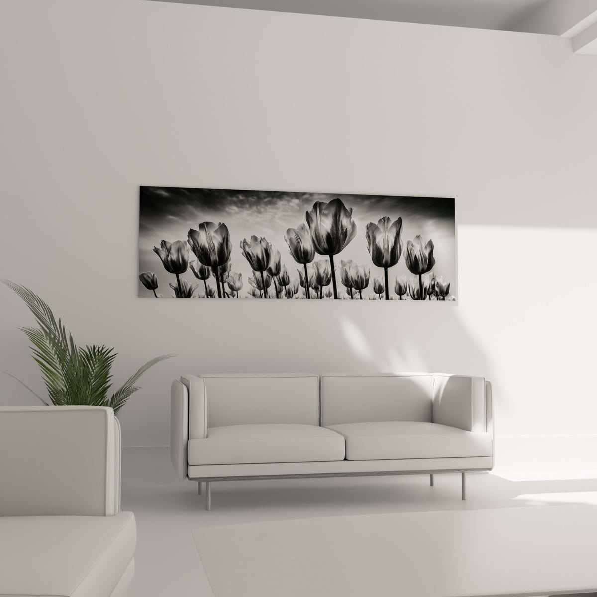 Silhouettes de tulipes grises et blanches en contre-jour, disposées au-dessus d'un canapé dans un salon lumineux