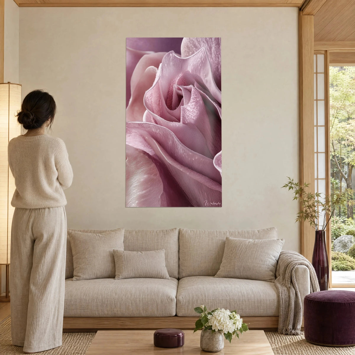 Gemälde Tulpenblütenblätter in Puderrosa, seidige mauve Falten, Frau von hinten davor, über einem Sofa in einem hellen Wohnzimmer