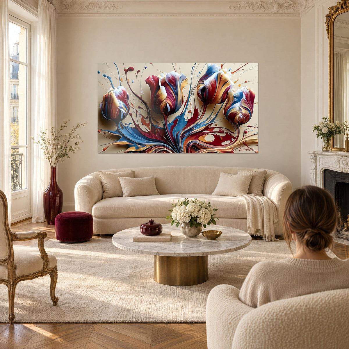 Tableau tulipes en éclaboussures bordeaux, bleu acier et or, femme de dos, au-dessus d'un canapé dans un salon lumineux