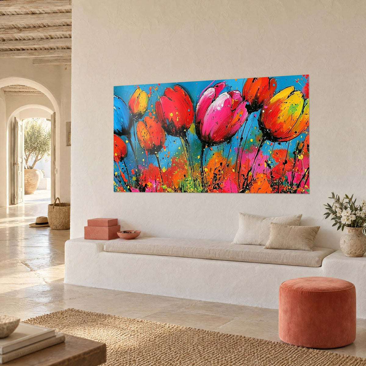Cuadro ramo de flores naranjas y amarillas de tallos entintados, cielo turquesa, colgado en una pared blanca junto a un banco de piedra
