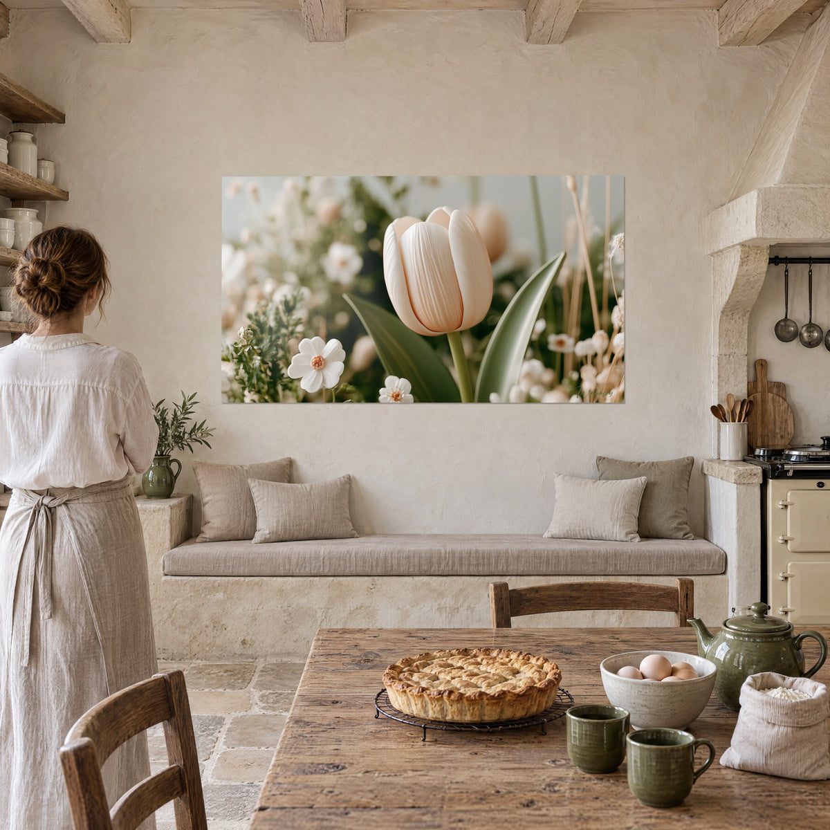 Tableau tulipe pêche et tiges sauge, fleurs blanches à cœur orangé, face à une femme en tablier lin dans une cuisine en pierre