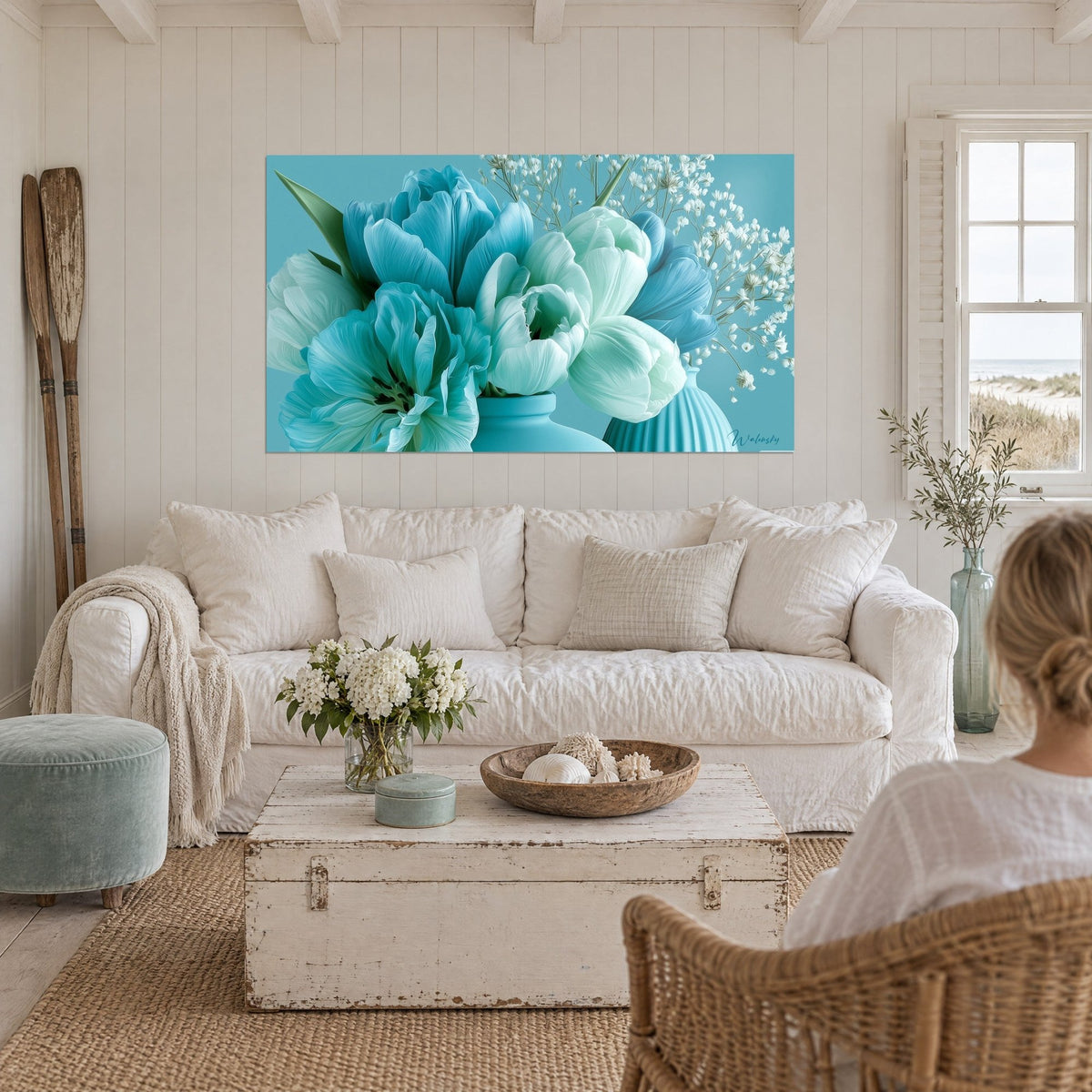 Tableau bouquet de tulipes turquoise et blanches, brins de gypsophile sur fond bleu, au-dessus d'un canapé dans un salon lumineux