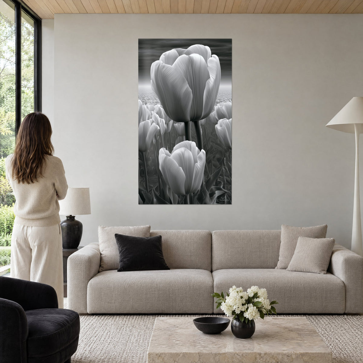 Quadro tulipani bianchi in bianco e nero, petali striati e cielo grigio di tempesta, sopra un divano in un soggiorno luminoso