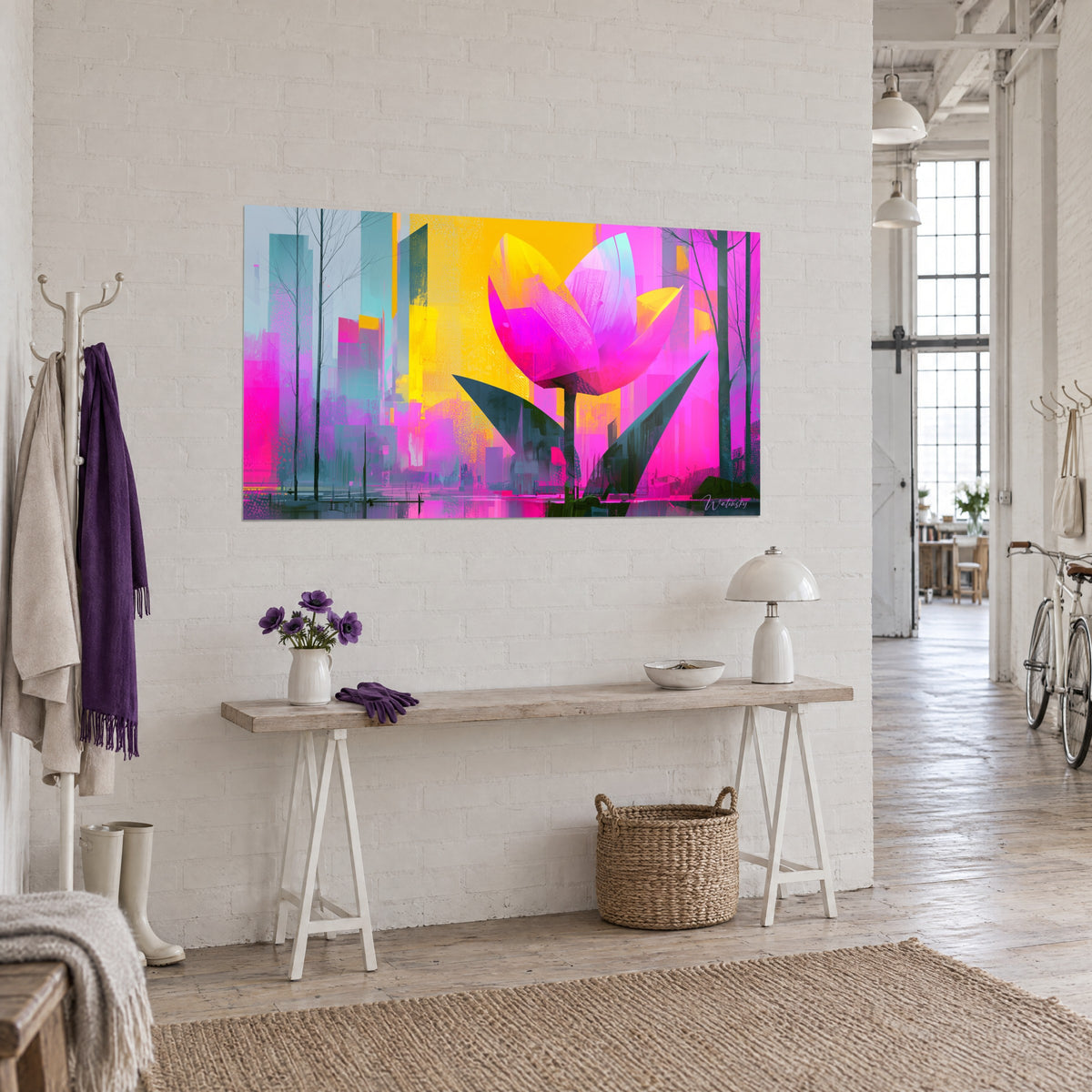 Wall art of a vibrant pink flower with broken brushstrokes, sunny yellow background and blue-grey towers, three-quarter view on a white loft wall