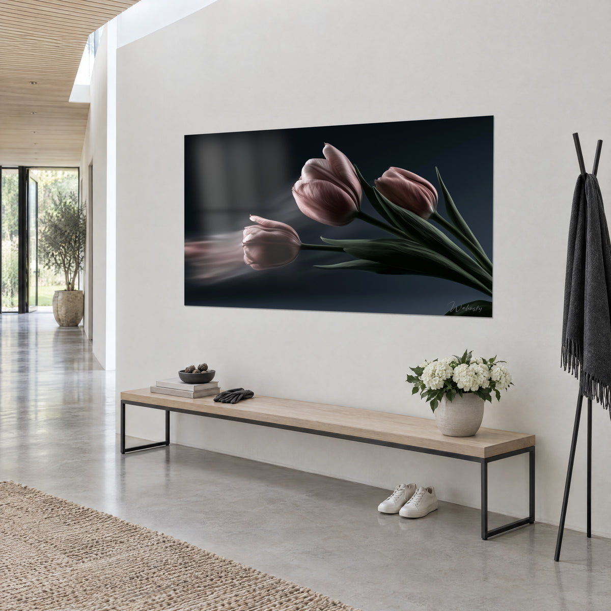 Tableau trois tulipes vieux rose aux pétales satinés, feuilles vert sapin sur fond bleu nuit, vue de trois-quarts dans un couloir lumineux
