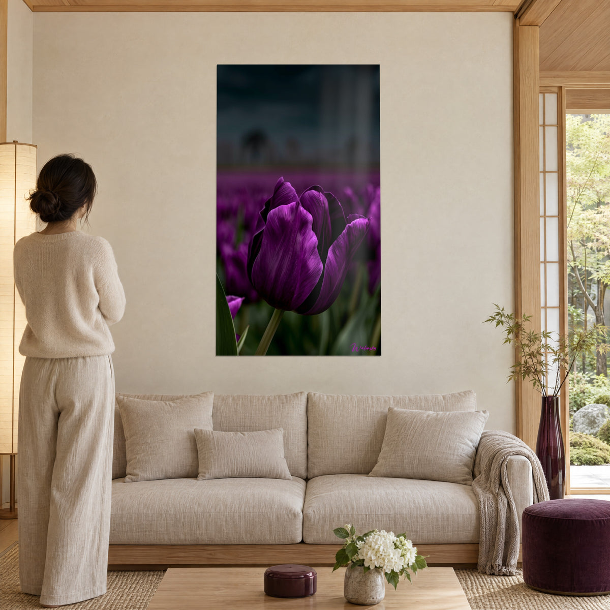 Gemälde Lila Tulpe mit samtigen Blütenblättern vor grauem Gewitterhimmel, Frau von hinten, über einem Sofa in einem hellen Wohnzimmer