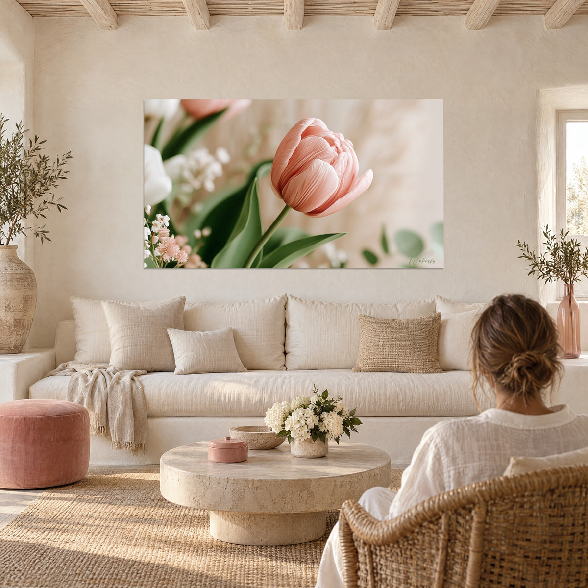 Quadro con un tulipano rosa salmone dai petali venati su gypsophila bianca e foglie verdi, appeso sopra un divano in un soggiorno luminoso