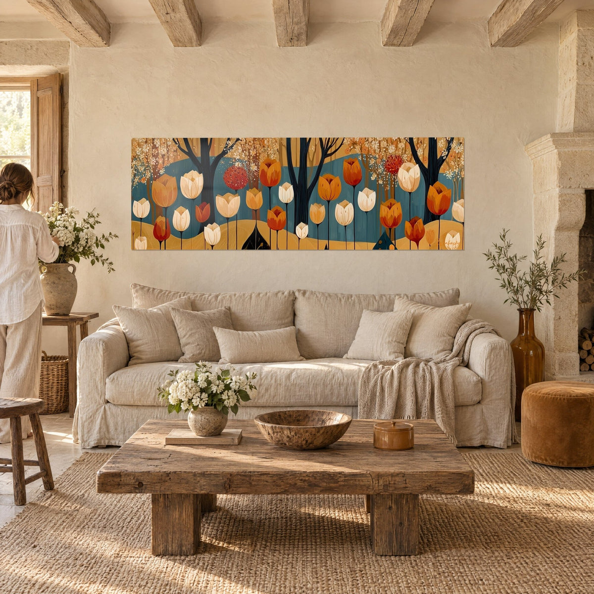Quadro tulipani ocra e bianco crema davanti a tronchi neri, sfondo blu anatra, sopra un divano in un soggiorno luminoso