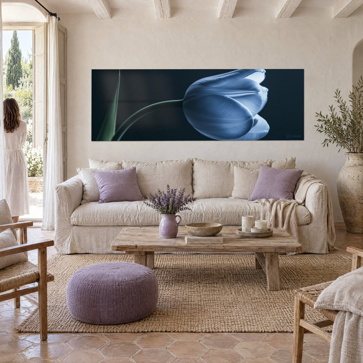 Tableau fleur bleu glacier sur fond anthracite, tige verte courbe, pétales veinés, au-dessus d'un canapé dans un salon lumineux