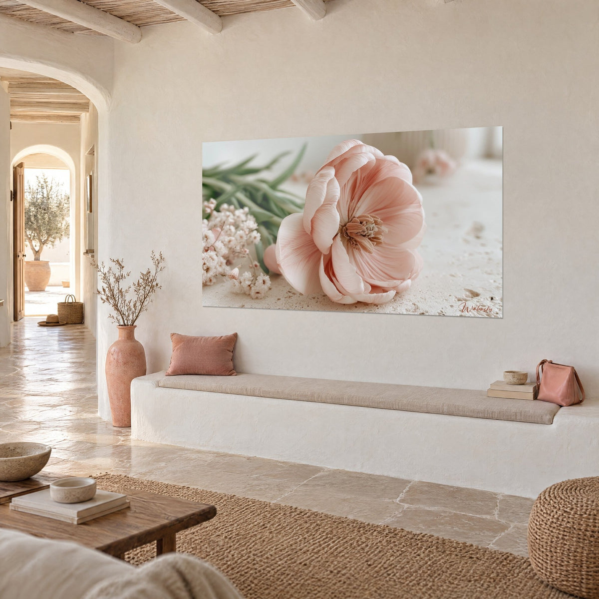 Tableau fleur ouverte rose poudré et crème, cœur brun velouté, tiges vertes floues, mur chaulé dans une maison méditerranéenne