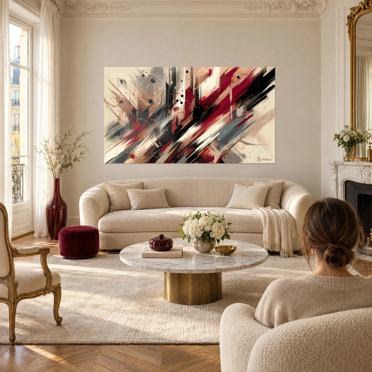 Quadro con pennellate astratte bordeaux e nere su fondo crema, sopra un divano in un soggiorno luminoso
