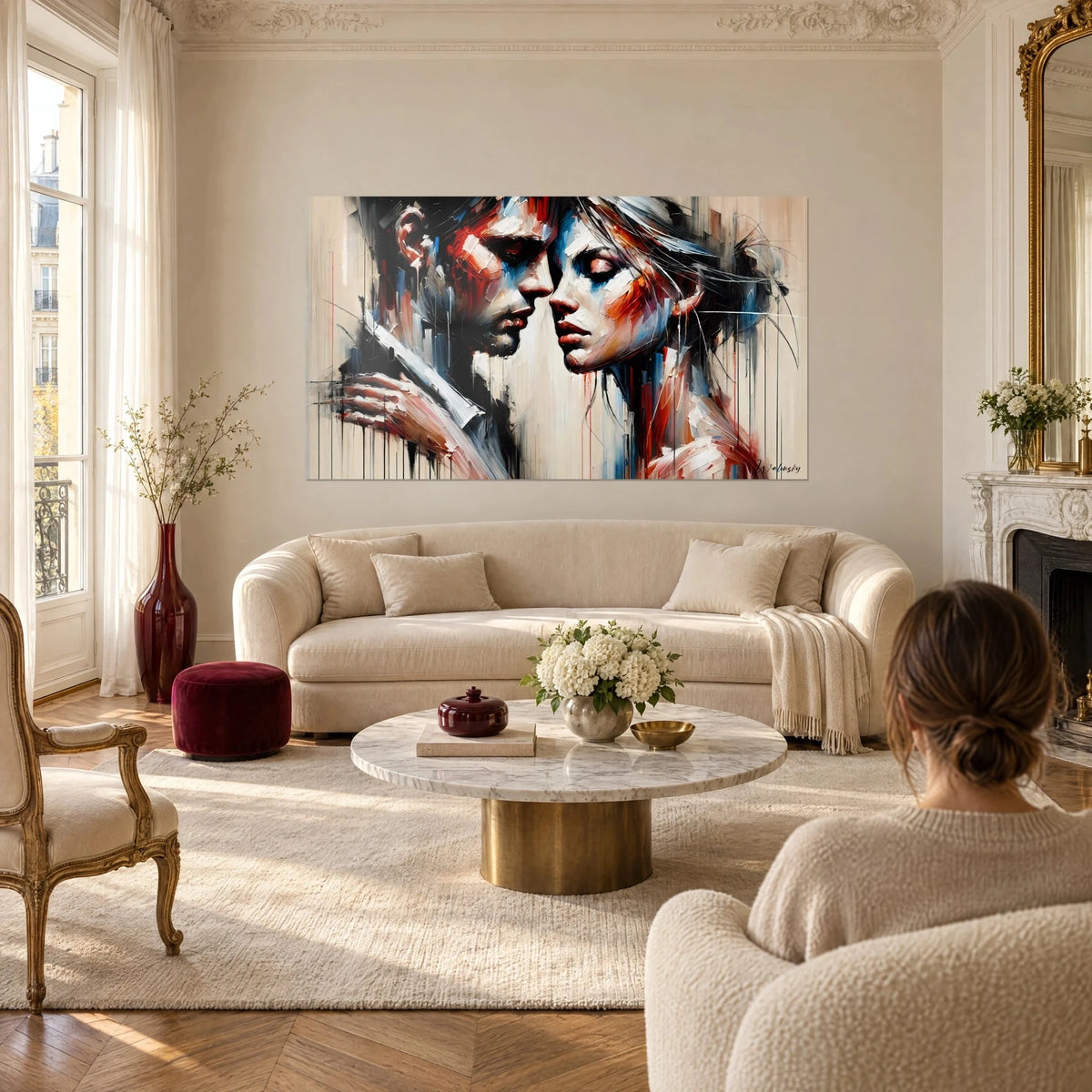 Tableau couple enlacé front contre front, rouge brique et bleu cobalt, coulures verticales, au-dessus d'un canapé dans un salon lumineux