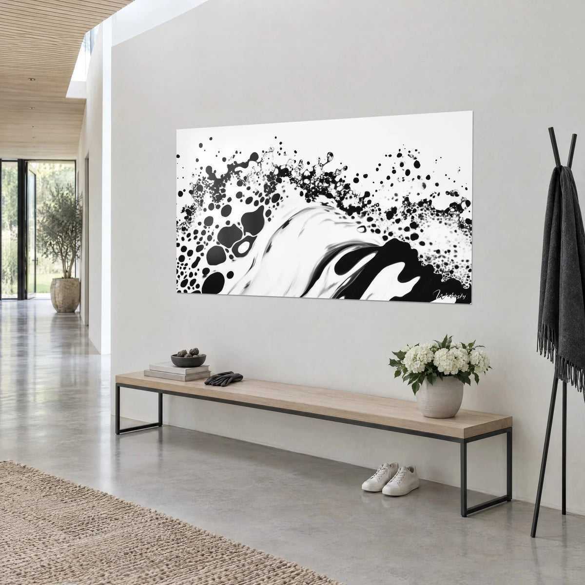 Wall art black ink speckled wave on cream white, bubbles and droplets, on a grey wall with an oak bench