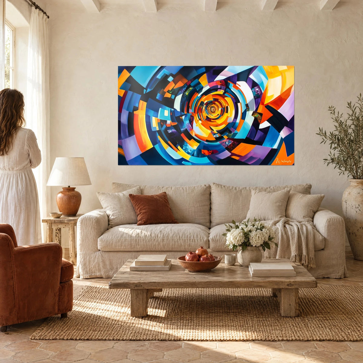 Cuadro con una espiral hipnótica en arcos naranja y azul cobalto, una pareja de espaldas, sobre un sofá en un salón luminoso