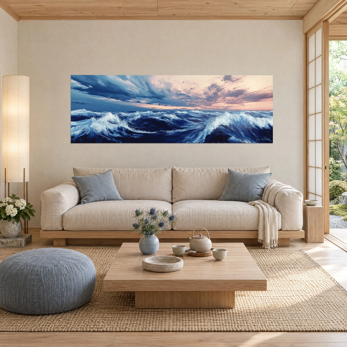 Gemälde mit brechender Welle und weißen Schaumkämmen, nachtblaues Meer und zartrosa Himmel, über einem Sofa in einem hellen Wohnzimmer