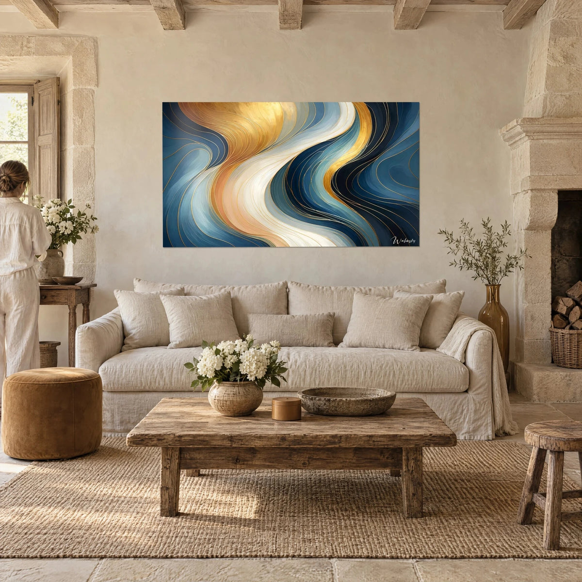 Wall art with golden and navy blue rolling waves, ivory ribbons, hung above a sofa in a bright living room