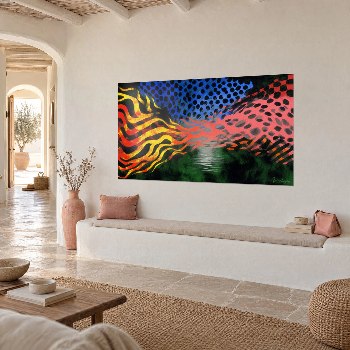 Cuadro llama rayada naranja y amarilla que se funde en una trama rosa, bosque verde oscuro abajo, sobre una pared blanca de una casa mediterránea
