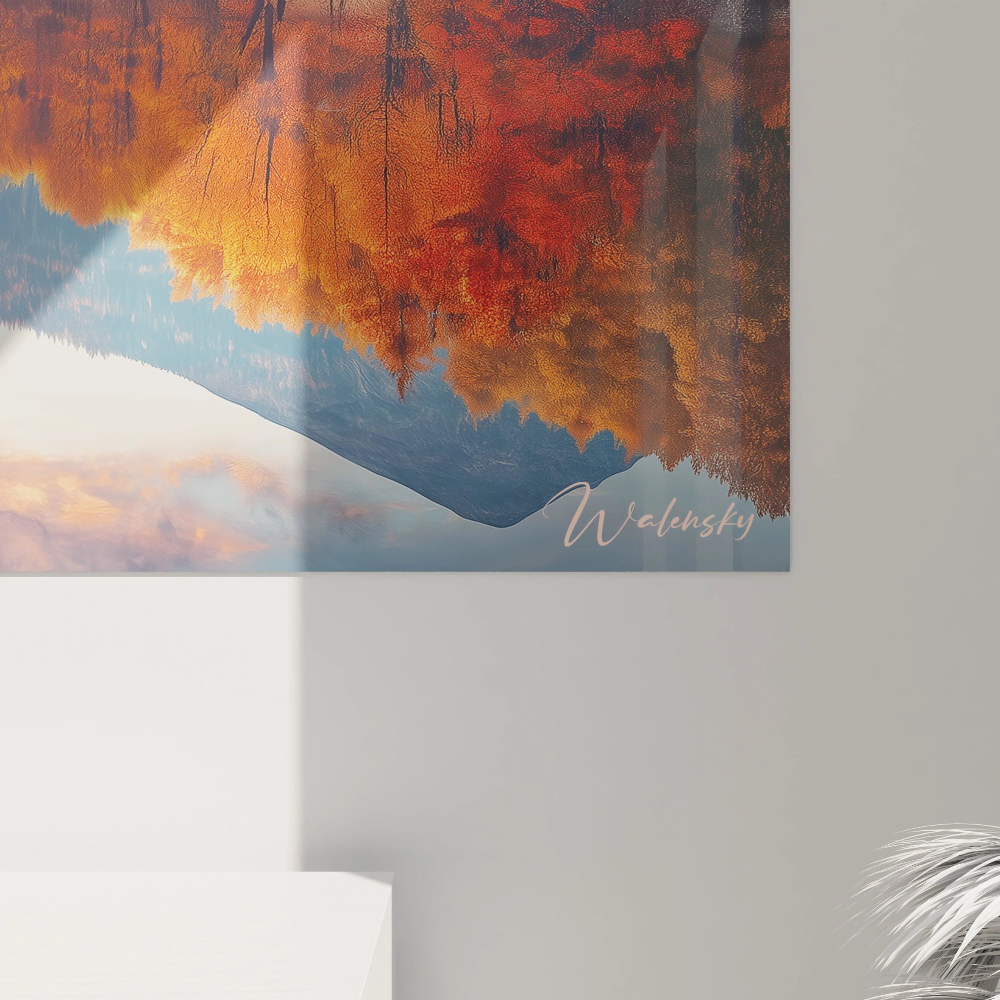 Tableau forêt illustrant un paysage symétrique où des montagnes bleues entourées d'arbres orangés se reflètent dans l'eau calme d'un lac, avec une lumière douce qui baigne la scène et accentue les contrastes entre les teintes chaudes et froides.
