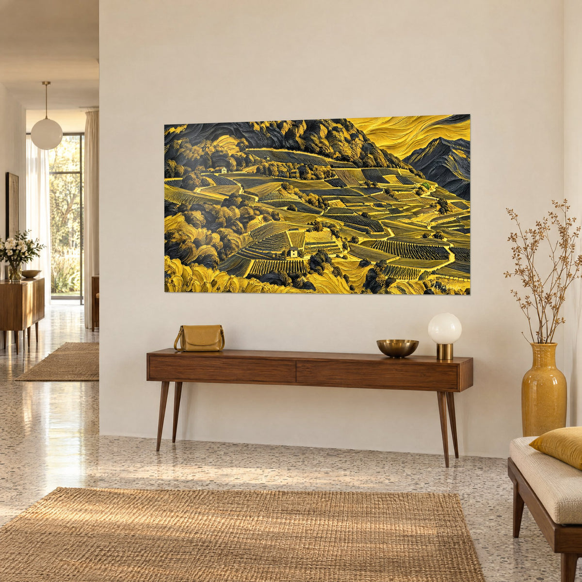 Tableau coteaux de vigne ocre et gris ardoise, petites maisons de pierre parmi les rangs, sur un mur beige derrière une console en bois