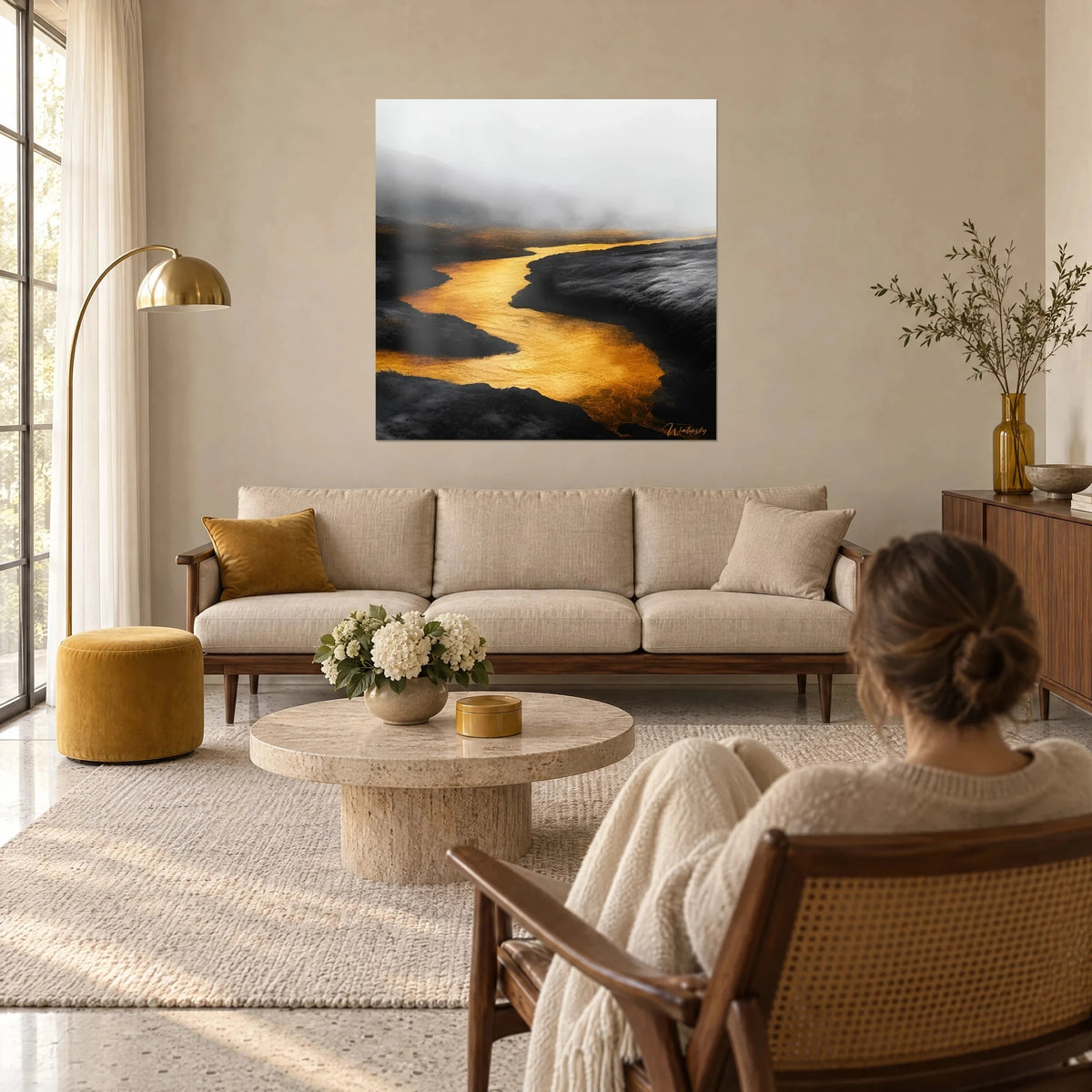 Cuadro de un río dorado líquido que serpentea entre turberas negras bajo la niebla gris, mujer de espaldas, sobre un sofá en un salón luminoso