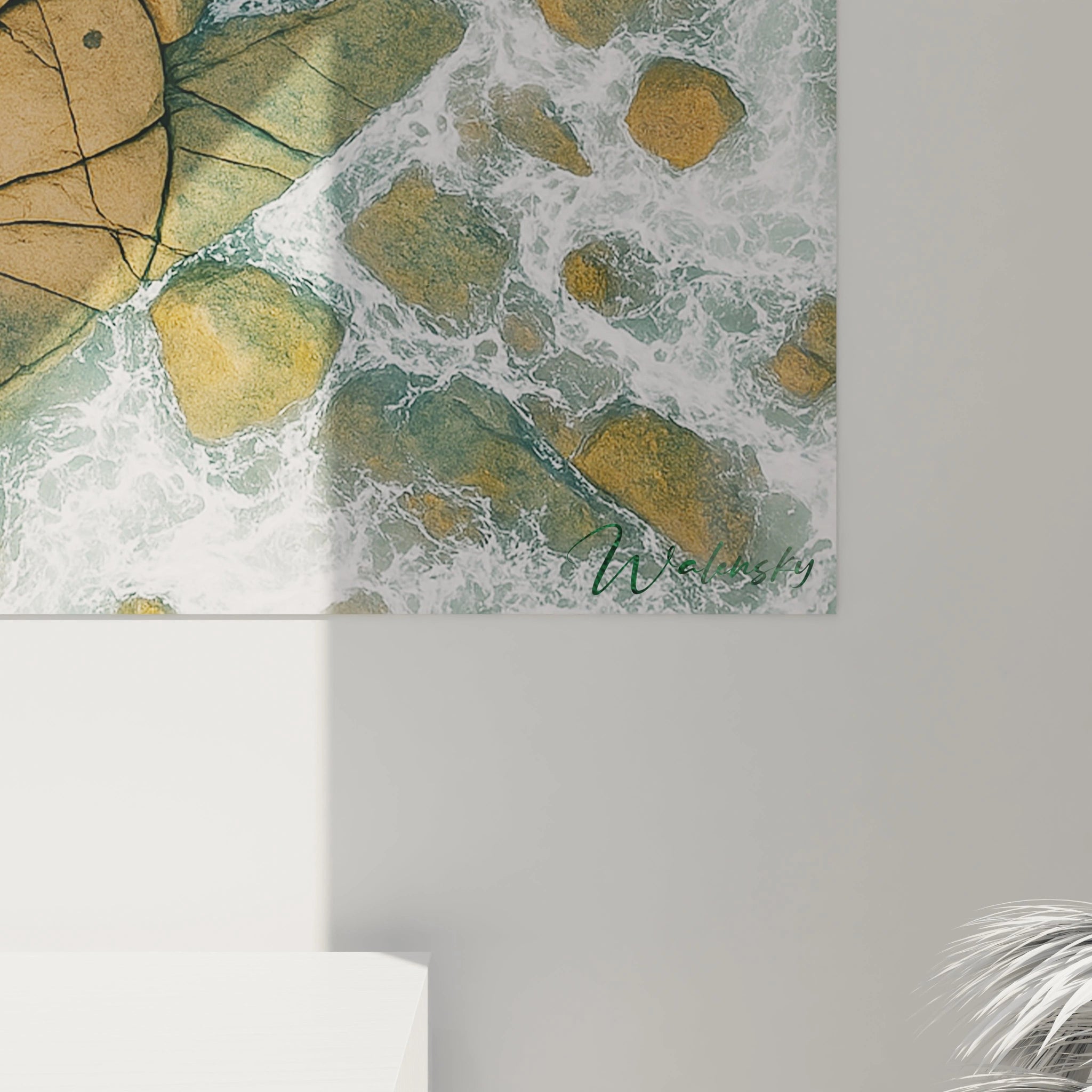 Un tableau vue aérienne représentant un littoral sauvage avec des dalles rocheuses beiges traversées de fissures géométriques. L'eau turquoise crée des motifs d'écume blanche autour des rochers isolés, tandis qu'une touche de verdure intense complète la composition.
