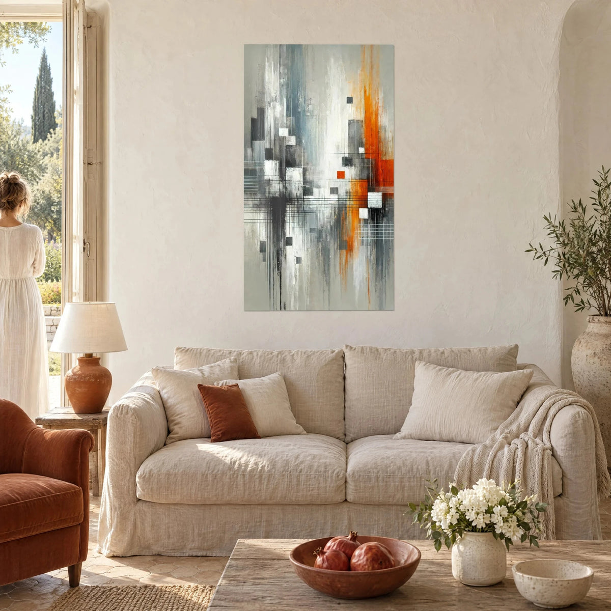 Tableau cité abstraite en bandes grises et orange, carrés blancs et noirs, au-dessus d'un canapé dans un salon lumineux