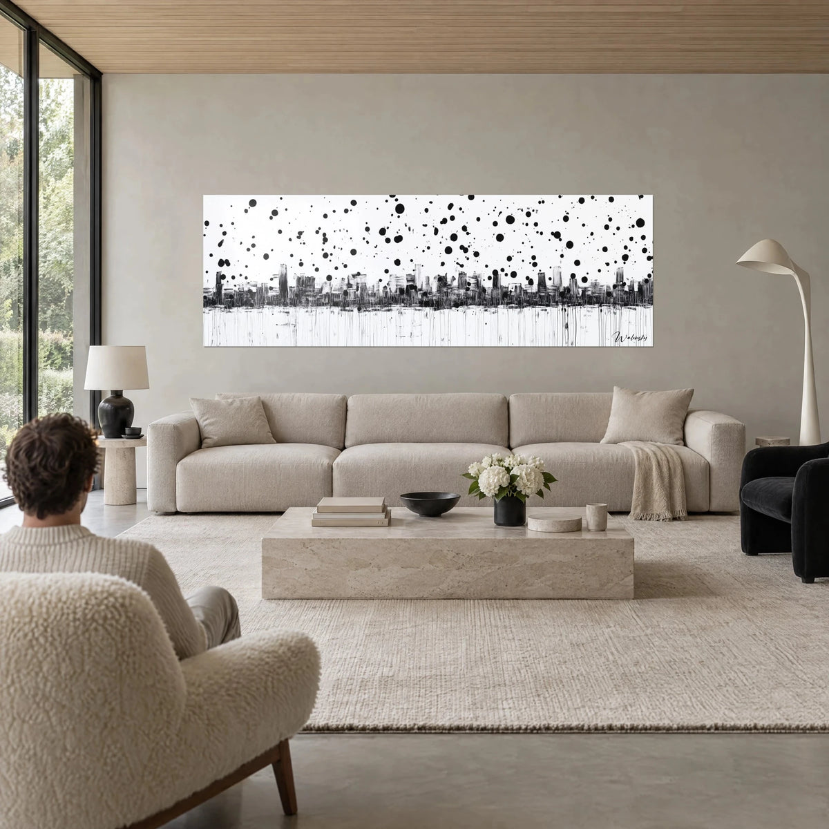 Wall art black urban skyline on white background, rain of round ink splashes, vertical drips, above a sofa in a bright living room