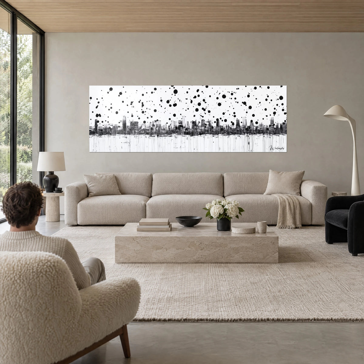 Gemälde urbane Skyline in Schwarz auf weißem Hintergrund, regen aus runden Tintenspritzern, senkrechte Tropfspuren, über einem Sofa in einem hellen Wohnzimmer