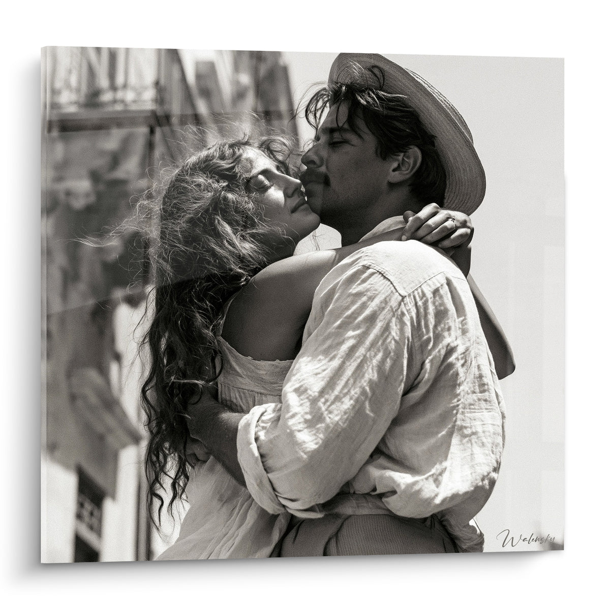 Couple enlacé en noir et blanc, chapeau de paille fauve, cheveux bouclés bruns, baiser passionné