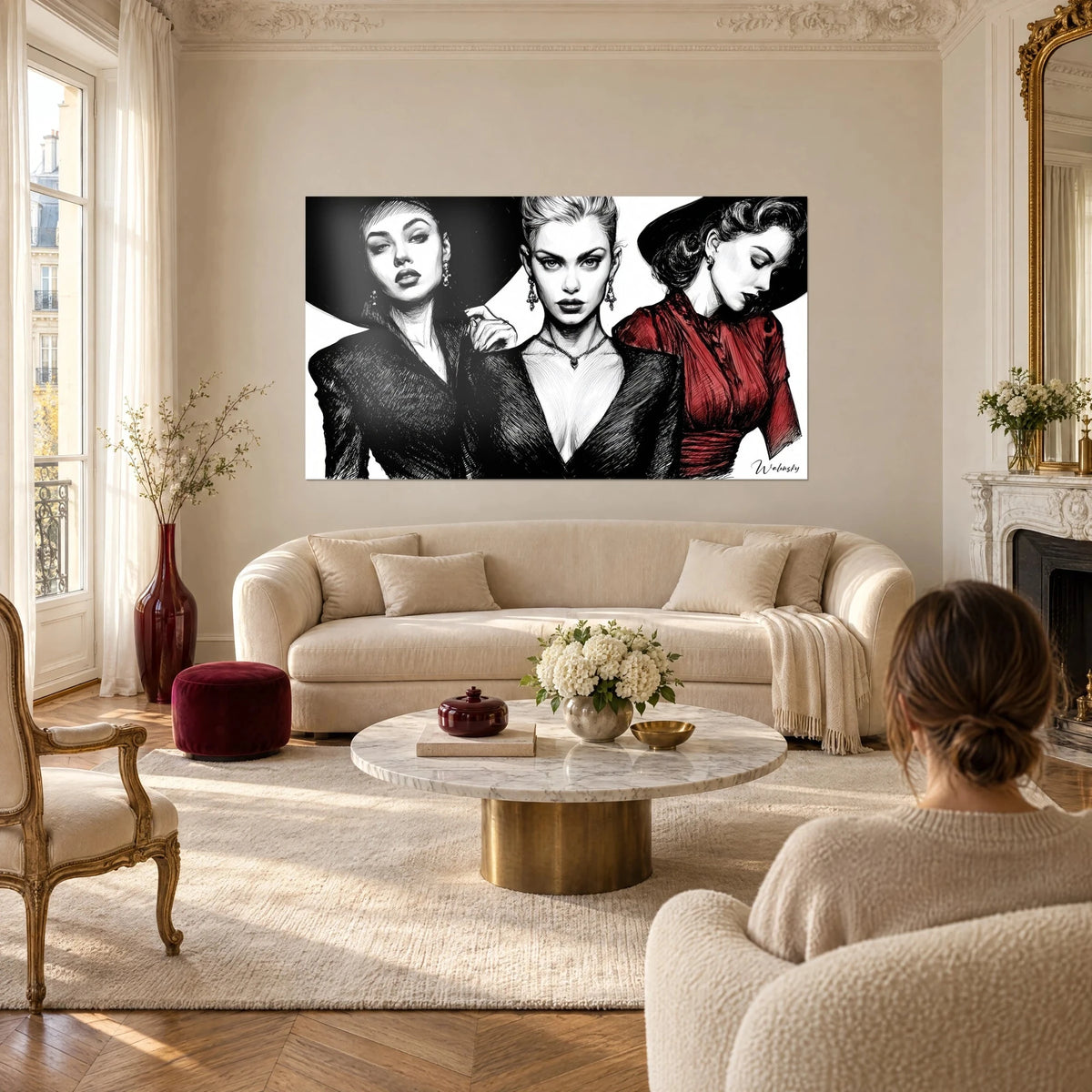 Schilderij drie modellen in zwart-wit, karmijnrode jurk rechts, brede zwarte hoed, boven een bank in een lichte woonkamer