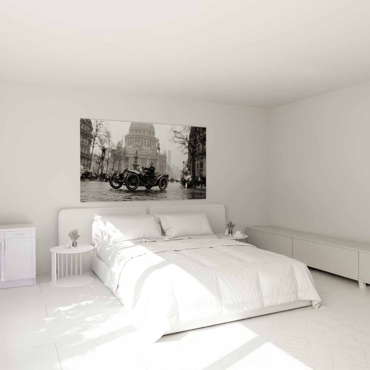 Roadster noir et blanc conduit par un homme moustachu, accroché au-dessus d'un lit dans une chambre claire