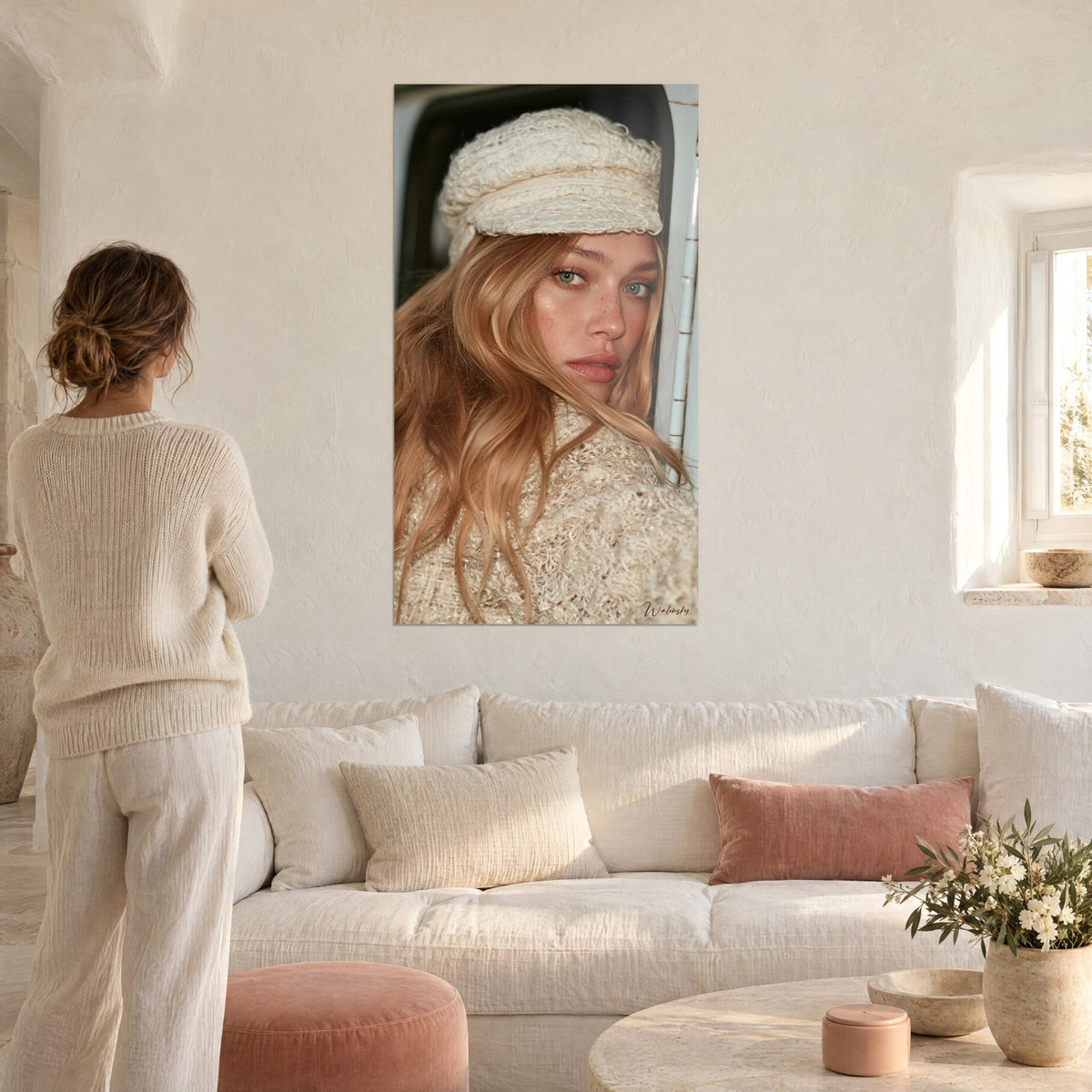 Cuadro retrato de una joven rubia con gorro de lana marfil, ojos azul claro, sobre un sofá en un salón luminoso