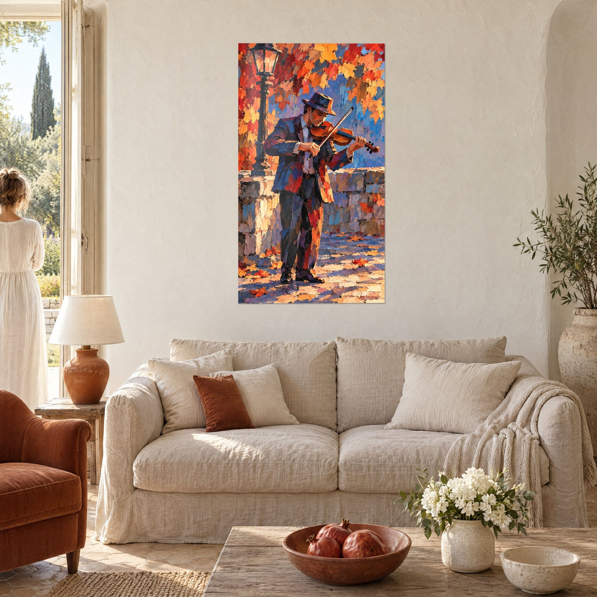 Tableau violoniste au chapeau bleu jouant sous un feuillage rouge et orangé, au-dessus d'un canapé dans un salon lumineux
