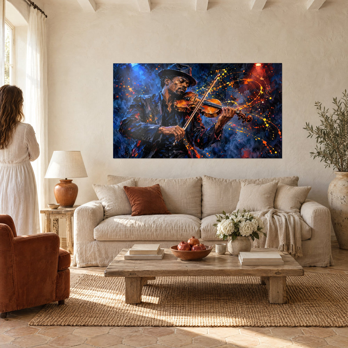 Tableau violoniste au chapeau noir, veste bleu nuit et éclaboussures orangées, couple de dos, au-dessus d'un canapé dans un salon lumineux
