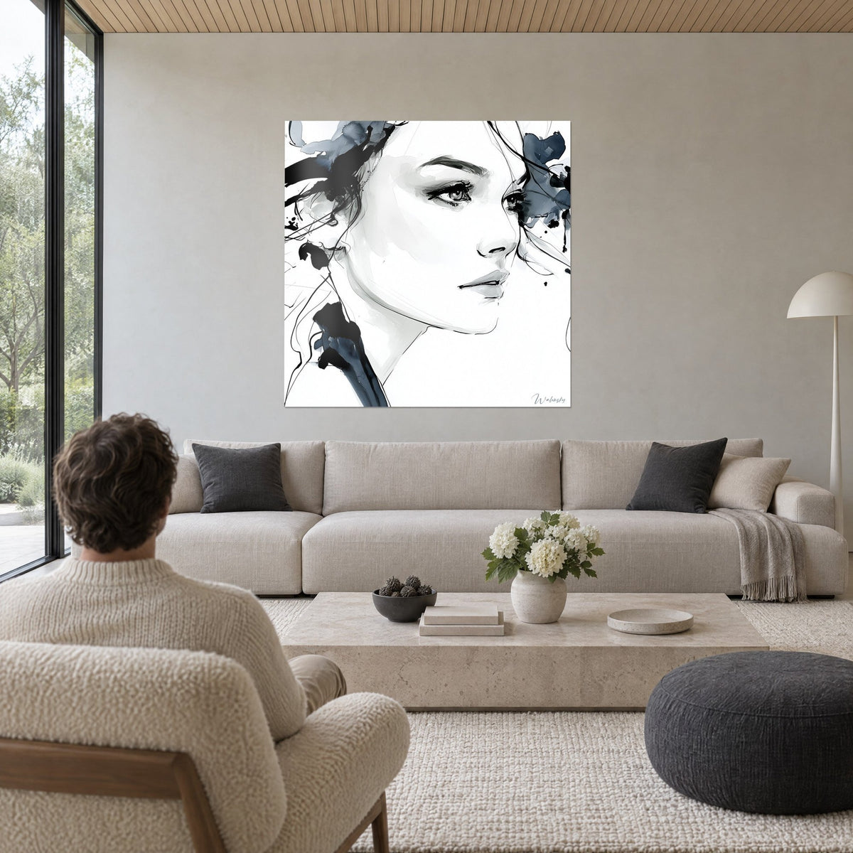 Wall art female portrait in profile in black ink and slate blue, almond-shaped gaze, above a sofa in a bright living room