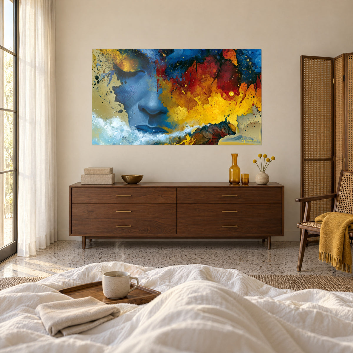 Wall art of an indigo mask with dark lashes, a hair of ochre and blood-red eruption, in front of a reclining couple, above a bed in a bright bedroom
