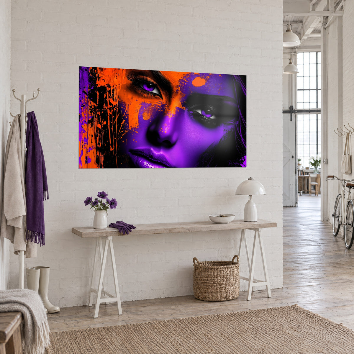 Quadro dallo sguardo frammentato, labbra malva lucide e colature arancioni su fondo nero, appeso a una parete bianca di loft