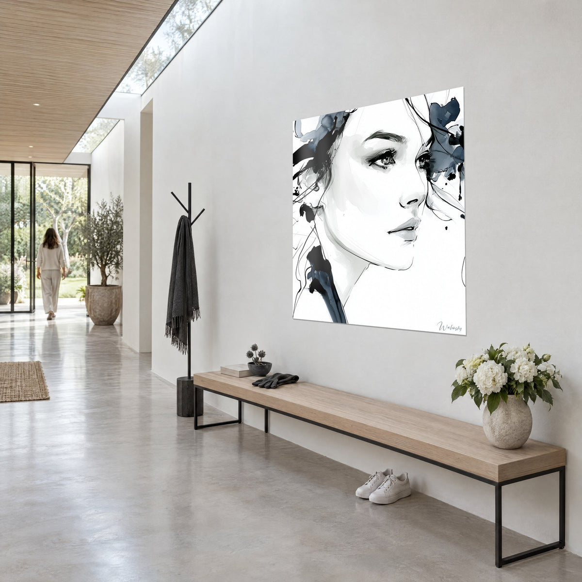 Wall art sketched female face in ink, black and midnight blue smudges on white background, hung in an architect-designed house hallway