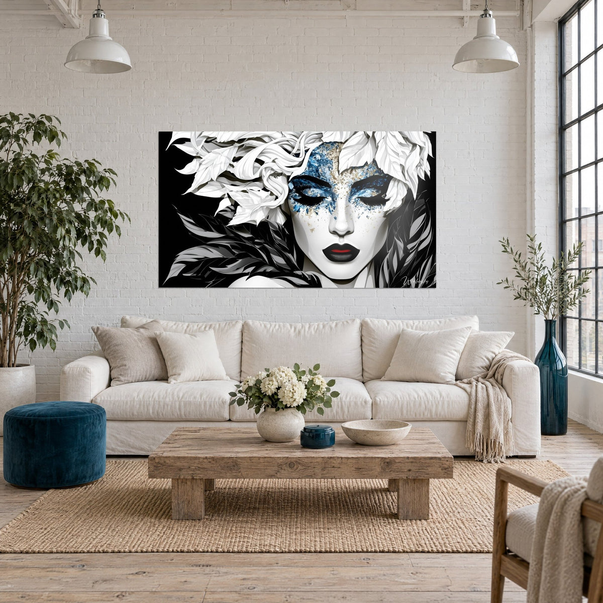 Wall art woman's face with closed eyelids, blue and gold sparkles, white and black feathers, above a sofa in a bright living room